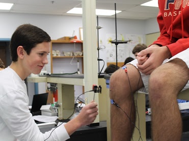students examining a boys knee 